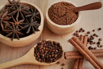 Stew powder and spices in a wooden cup with black background, industry concept