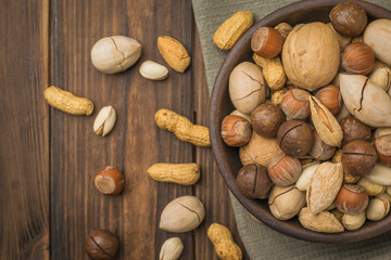 Mix various nuts in a deep bowl on the table.