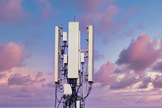 Telecommunication tower of 4G and 5G cellular. Macro Base Station. 5G radio network telecommunication equipment with radio modules and smart antennas mounted on a metal on cloulds sky background.