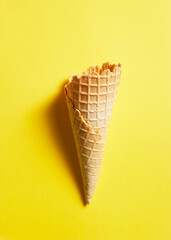 Sweet wafer cone on yellow background