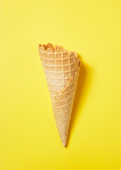 Sweet wafer cone on yellow background