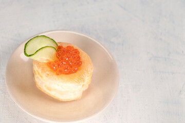 Appetizer with red caviar. Tartlets, red caviar, cucumber on a white background with space for your text. Delicious and healthy snack. Top view.