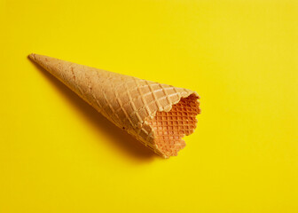 Sweet wafer cone on yellow background
