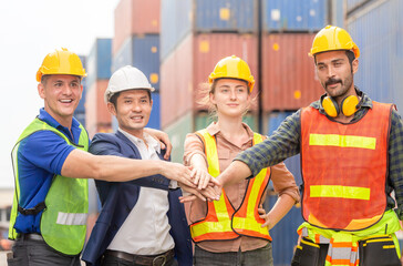 Happiness engineer and worker team group joining hands at cargo containers. Success Teamwork Concepts