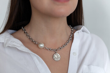 Beautiful model brunette in modern silver metal necklace chain