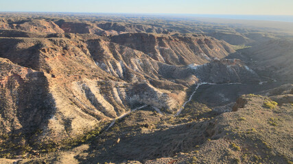 High drone view over a spectacular hilly red charles Knife Canyon on a foggy day during sunrise In...