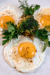 Fried eggs with fried broccoli and herbs