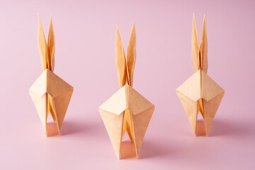 Paper origami bunny on pink background. Crafts made of paper. The minimal concept of Easter or the year of the rabbit. Easter Bunny