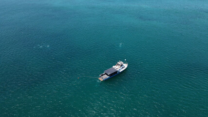 Fishing boat in turquoise water sea aerial shot