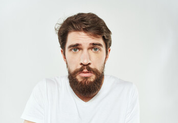 Bearded man in white T-shirt puzzled look sad face cropped look