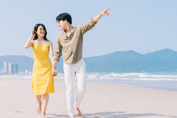 Young Asian couple enjoying summer vacation on the beach