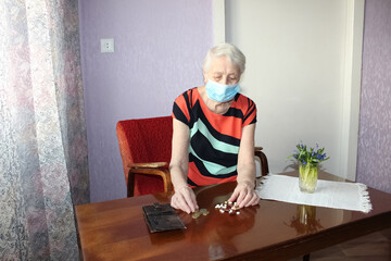 Happy positive smiling senior woman takes off protective medical mask from face outdoors