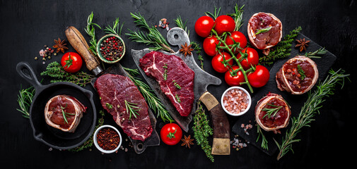 Variety of raw black angus prime meat steaks beef rump steak, Tenderloin fillet mignon or grilling with seasoning on black background. banner, menu recipe top view