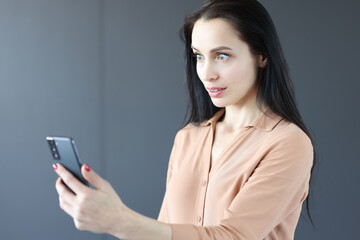 Fototapeta premium Surprised woman looking at mobile phone screen
