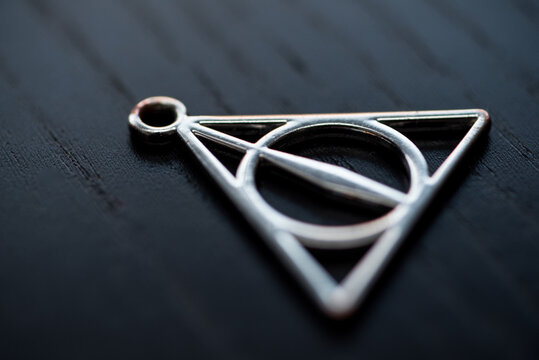 Close up silver necklace focus deathly hallows.