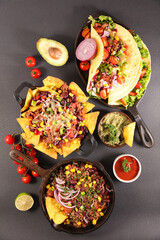 assorted of mexican food with fajitas, chili con carne and nachos with avocado, beef and cheese