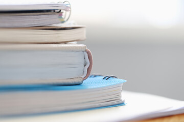 Stack of books and notebooks lying on table closeup