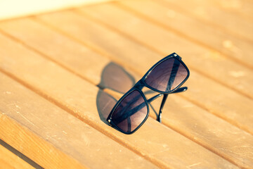 Fototapeta na wymiar Classic Sunglasses design for men and ladies with black lenses and black frame shoot outside in a summer day closeup. Selective focus. High quality photo