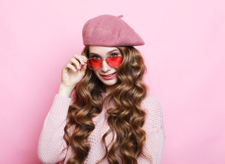 beautiful young female model with long wavy hair wearing pink beret , scarf and eyeglasses, close up