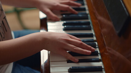 Obraz premium Close up of unidentified hands playing piano indoors. Pianist hands practicing.