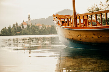 Lake Bled Slovenia. Beautiful mountain lake with small Pilgrimage Church. Traditional wooden boats...