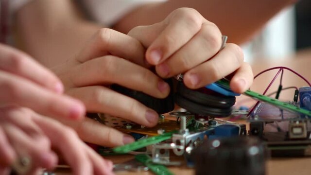 Marco video of teenagers hands linking different details on wooden table. 
