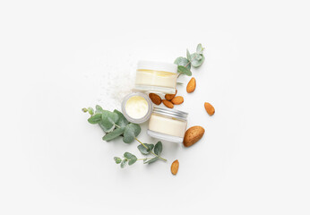 Composition with jars of natural cream on white background