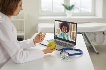 Fototapeta na wymiar Diverse doctor and client communicate online. Diet specialist, professional dietitian, hospital practitioner, physician, clinic cardiologist gives health recommendation to black African American woman
