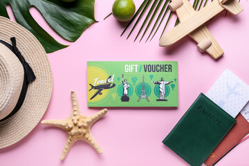 Set of travel accessories and gift voucher on color background