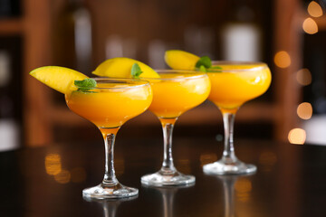 Glasses of tasty mango margarita on table in bar