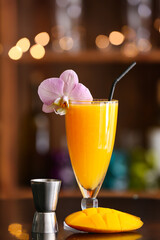 Glass of tasty mango margarita on table in bar