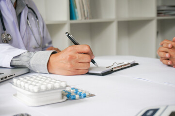 Fototapeta premium Medicine Doctor hand holding pack of different tablet blisters for patient. prescribe medicament. disease healing concept. Packaging of tablets and pills on the table.