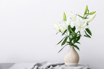 Vase with beautiful lily flowers on table in room