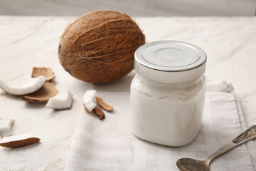 Fototapeta na wymiar Jar with coconut cream on light background