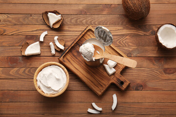 Spoon and metal can with coconut cream on wooden background