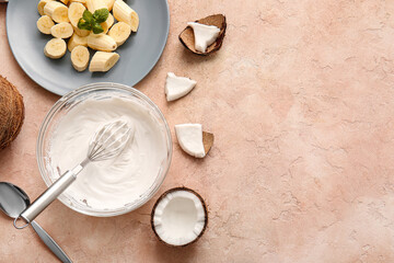 Bowl with coconut cream and whisk on color background