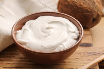 Bowl with coconut cream on wooden background, closeup