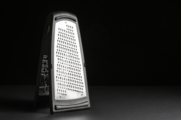 Metal grater on dark background