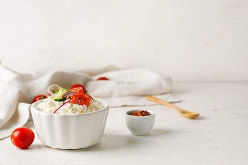 Bowl with cottage cheese on light background