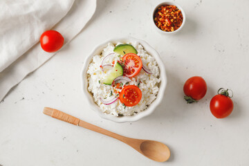 Bowl with cottage cheese on light background