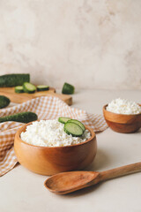 Bowls with cottage cheese on light background