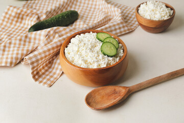 Bowls with cottage cheese on light background