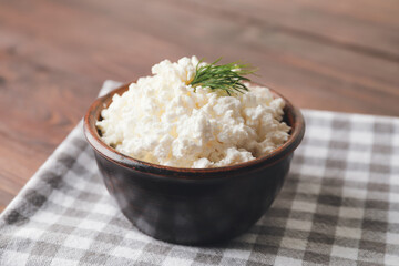 Bowl with cottage cheese on wooden background