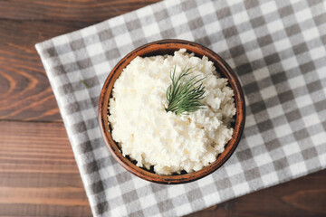 Bowl with cottage cheese on wooden background