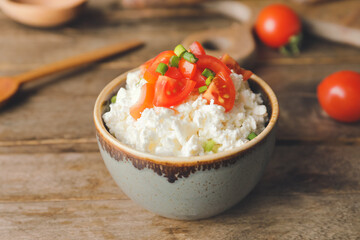 Bowl with cottage cheese on wooden background