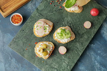 Tasty sandwiches with cottage cheese and vegetables on color background