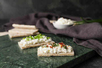 Crispbreads with cottage cheese on dark background