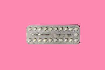 Birth control pills on pink, minimal flat lay