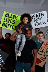 Cute african american boy on father shoulder