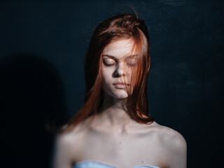 Fototapeta na wymiar Romantic woman with red hair on a dark background model close-up portrait